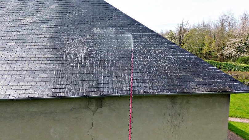 La perche télescopique Nettoyage à la perche télescopique sur une toiture en ardoises