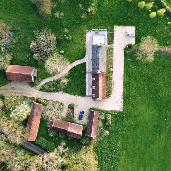 Vue aérienne par drone d'une propriété avec plusieurs bâtiments à toiture en tuiles