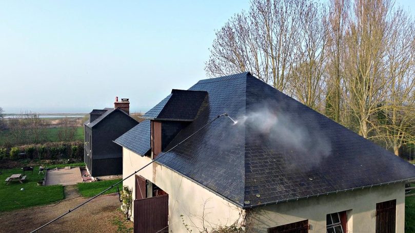 Nettoyage en cours Toiture en ardoises en cours de nettoyage à l'eau chaude par drone