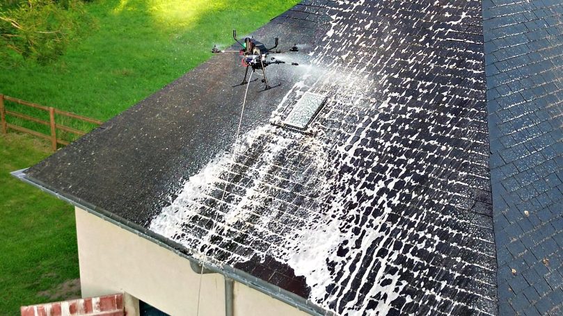 Le drone en action sur ardoises Drone HYDRO-NE projetant de l'eau chaude sur une toiture en ardoises